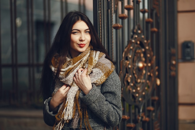 Girl walks. Woman in a coat. Brunette with a scarf.