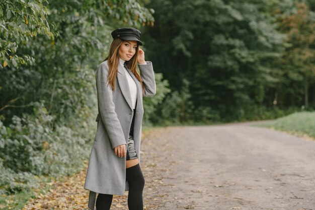 Girl walks. Woman in a gray coat. Brunette with a black cap.