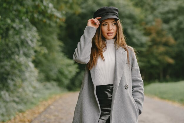 Girl walks. Woman in a gray coat. Brunette with a black cap.