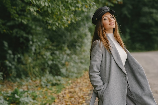 Girl walks. Woman in a gray coat. Brunette with a black cap.