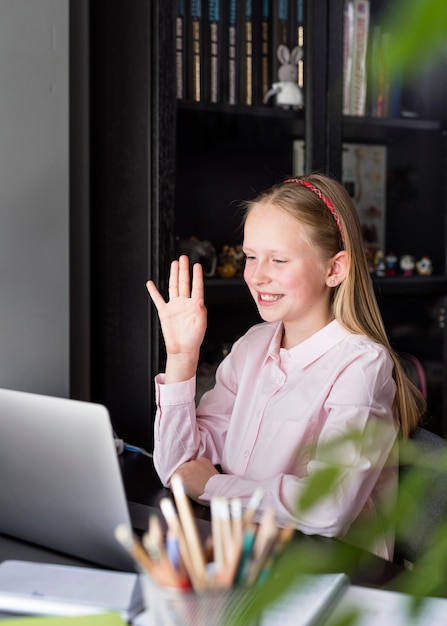 Free photo girl waving at her colleagues through her web camera