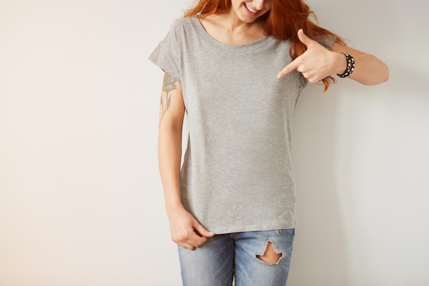 Free Photo girl wearing grey blank t-shirt standing on white wall