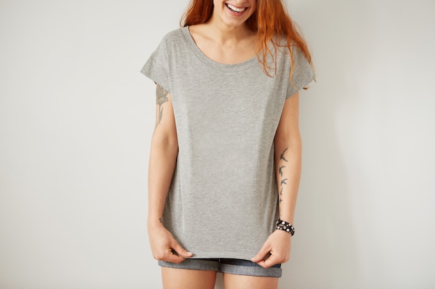 Free photo girl wearing grey blank t-shirt standing on white wall