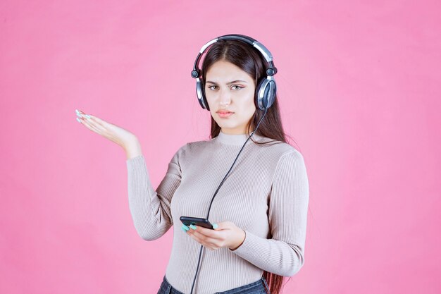 Girl wearing headphones and does not enjoy the music at her playlist