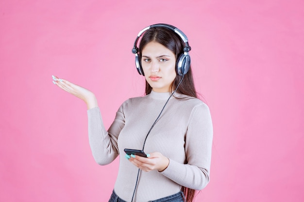 Girl wearing headphones and does not enjoy the music at her playlist