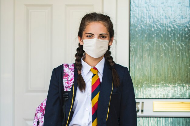 Girl wearing a mask and going to school in the new normal