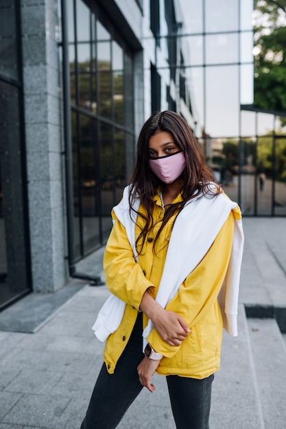 Free Photo girl wearing mask posing on street. fashion during quarantine of coronavirus outbreak.