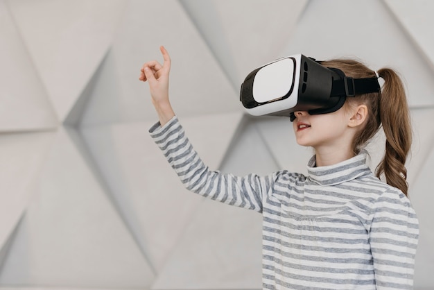 Girl wearing virtual reality headset and holding hand in the air