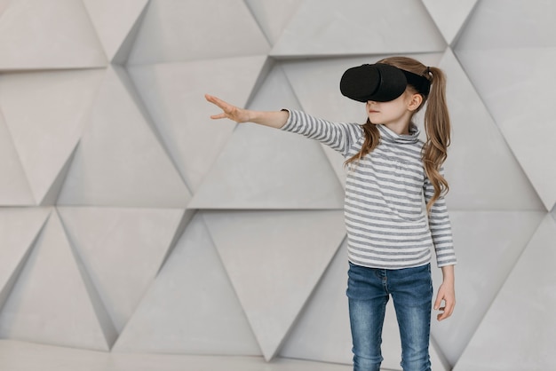 Girl wearing virtual reality headset and stretching her hand