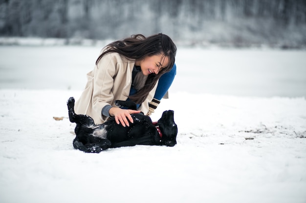 Girl in winter playing with dog