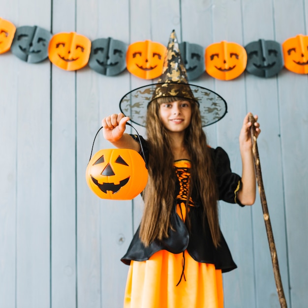 Free photo girl in witch costume holding halloween basket