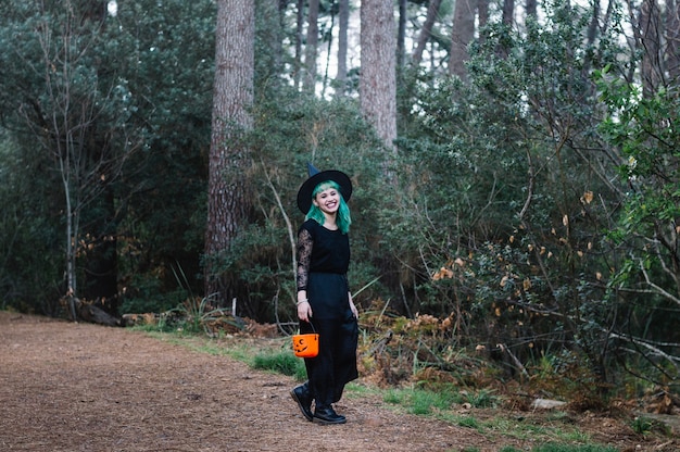 Free photo girl in witch hat laughing in forest