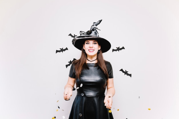 Free photo girl in witch hat with confetti