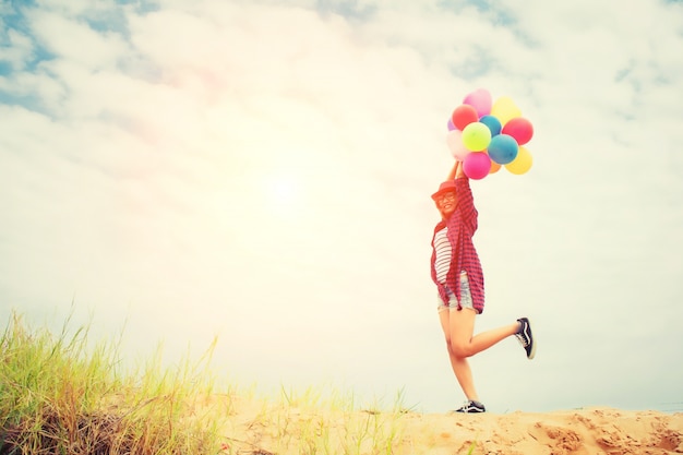 Free photo girl with balloons in the beach