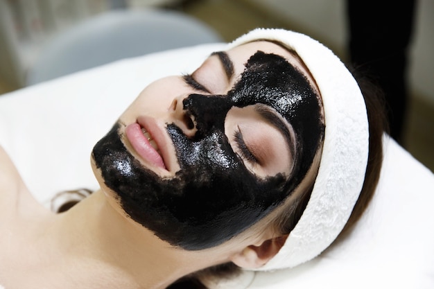 Girl with black mask lies on the table  in spa saloon