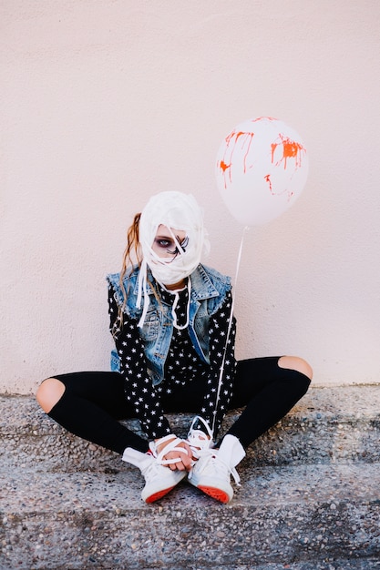 Free photo girl with bondaged face and blood balloon