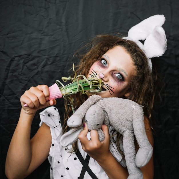 Girl with bunny ears eating green onion