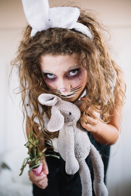 Girl with bunny ears holding toy 