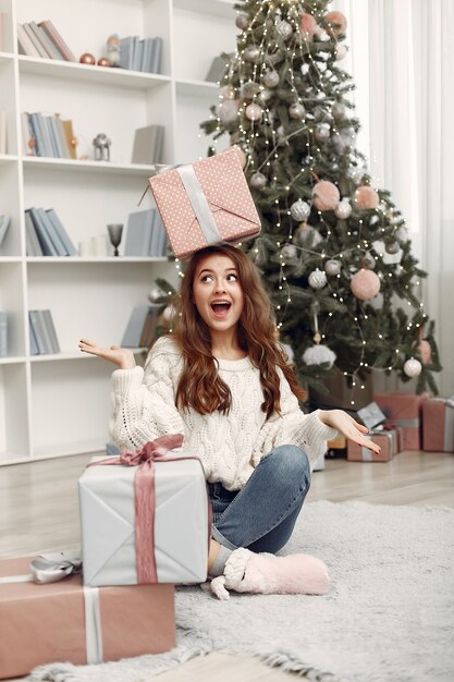 Girl with Christmas boxes. Woman at home. Ladu preparing for holidays.