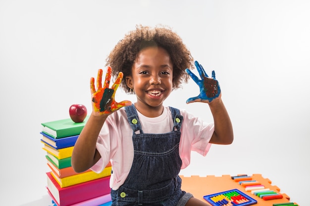 Girl with colored hands with paint in studio