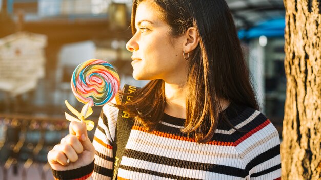 Girl with colorful lollipop illuminated by the sun