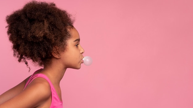 Girl with curly hair making a bubble gum