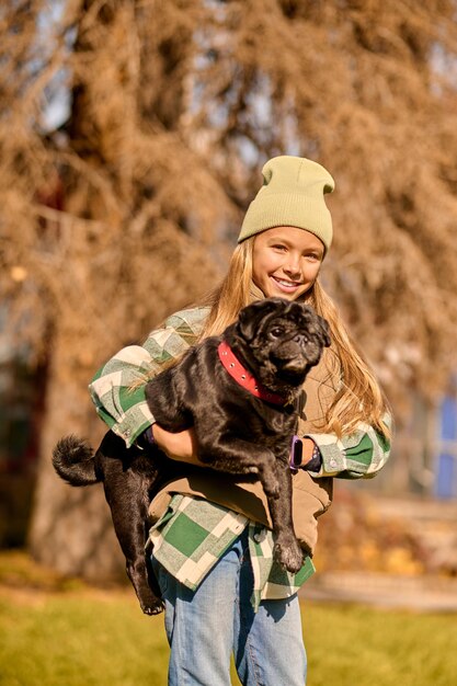 Girl with a dog. Pretty blonde girl holding her dog and smiling