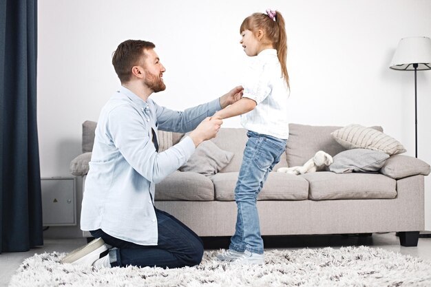 Girl with Down syndrome and her father sitting on a floor and talkiing together