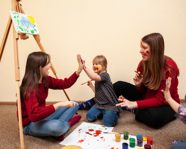 Girl with down syndrome high-fiving while painting