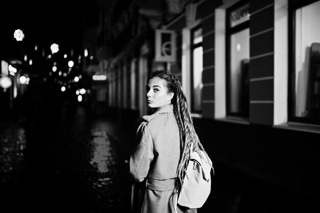 Free Photo girl with dreadlocks walking at night street of city