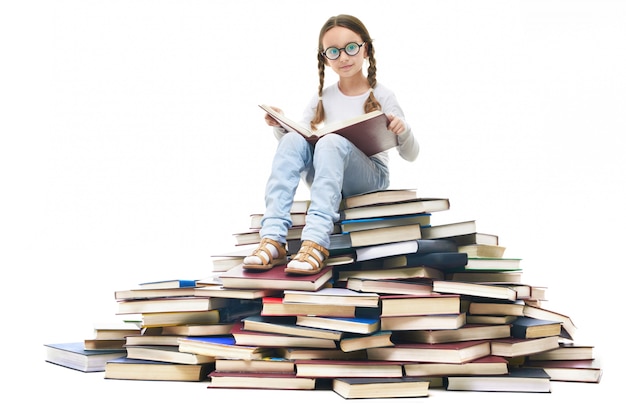 Free photo girl with glasses sitting on a pile of books