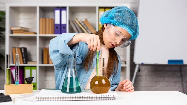 Girl with hair net doing science experiments with test tubes