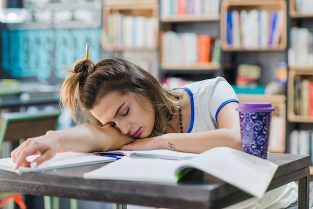 Free photo girl with hairbun sleeping on table