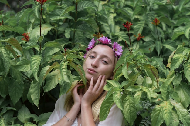 Free photo girl with hands on face and surrounded by plants