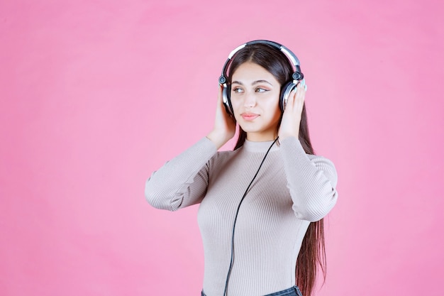 Girl with headphones listening the music and feeling happy