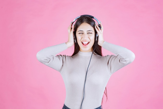 Girl with headphones listening the music and feeling happy