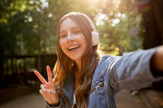 Free photo girl with headphones and peace sign