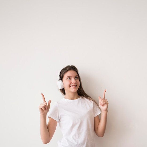 Girl with headphones pointing