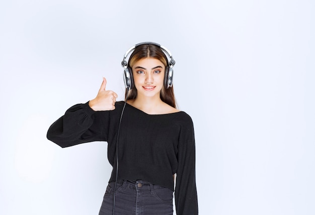 Free Photo girl with headphones showing satisfaction sign. high quality photo