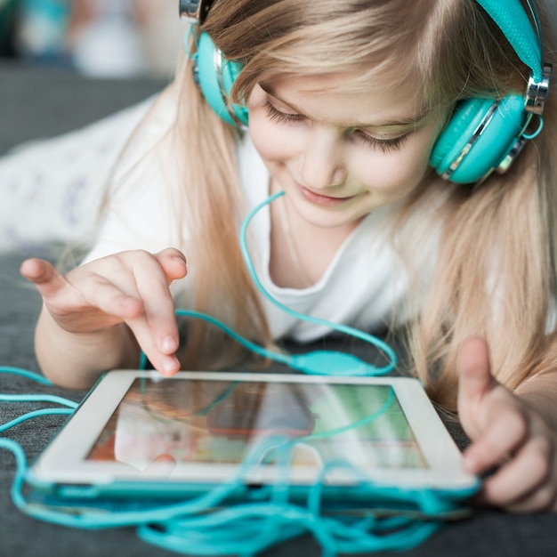 Free Photo girl with headphones touching tablet