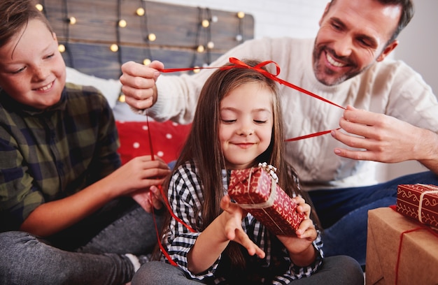 Free photo girl with her family opening christmas present