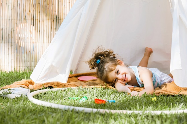 Free photo girl with hula hoop lying in tent