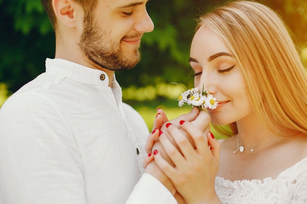 Free photo girl with light hair and a white dress in a sunny forest with her boyfriend