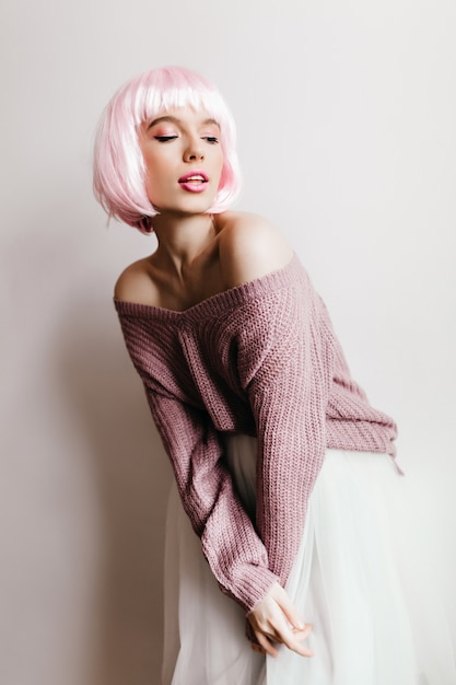 Free Photo  girl with light-pink hair posing in white skirt. indoor photo of pensive european young woman wears short periwig.