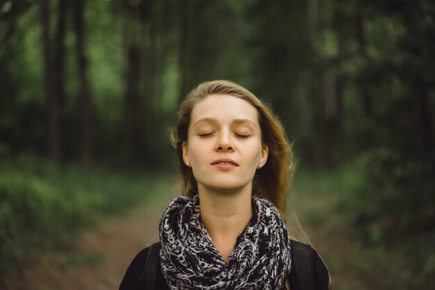 girl with long hair walks through the forest.