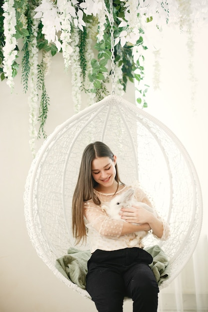 Free photo girl with long hair. white rabbit in girl's arms.