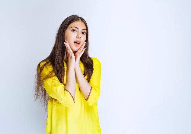 Girl with long hairs looks surprized and confused.