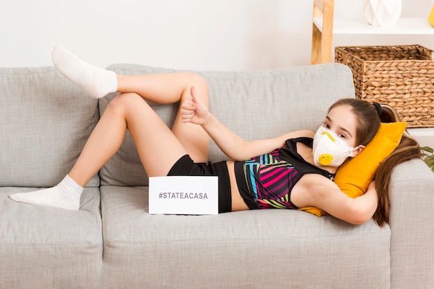 Girl with mask sitting on couch