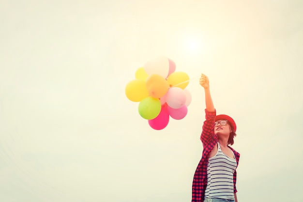 Free photo girl with a red hat and balloons