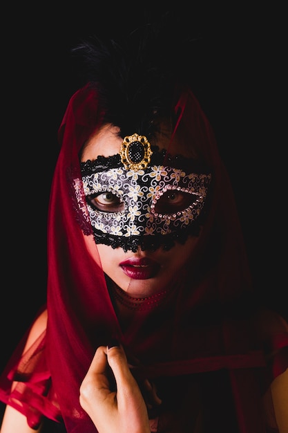 Girl with a red scarf on her head and a venetian mask